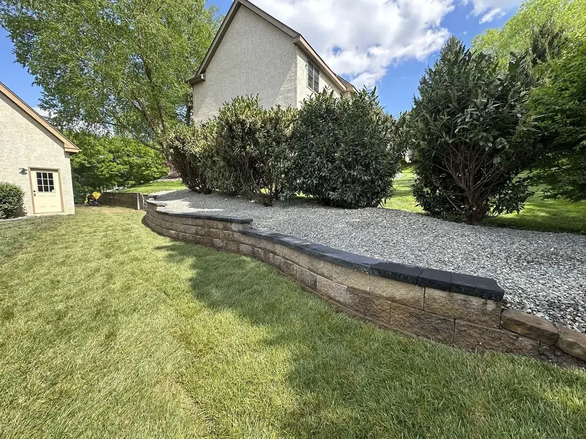 Curved segmental retaining wall with charcoal caps and gravel bed in Chester County PA