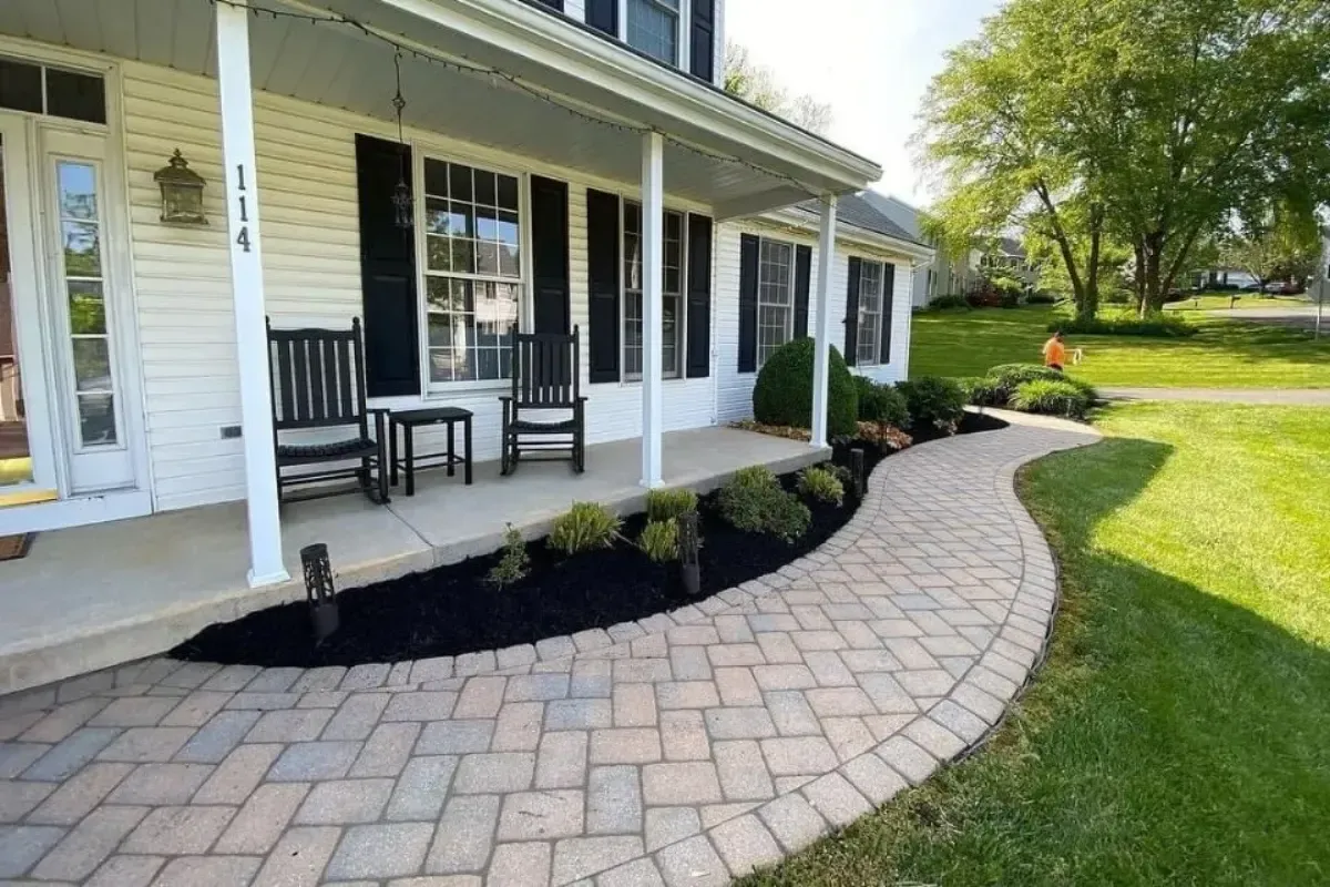 Curved front porch paver walkway with landscape lighting and mulch beds in Chester County PA