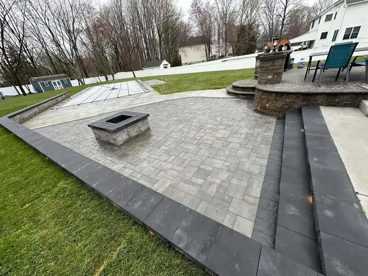Paver patio with fire pit outdoor kitchen and step lighting in Chester County PA