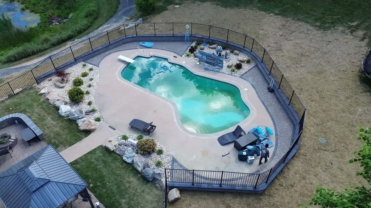 Luxury freeform pool with water feature boulder landscaping and pergola in Chester County PA