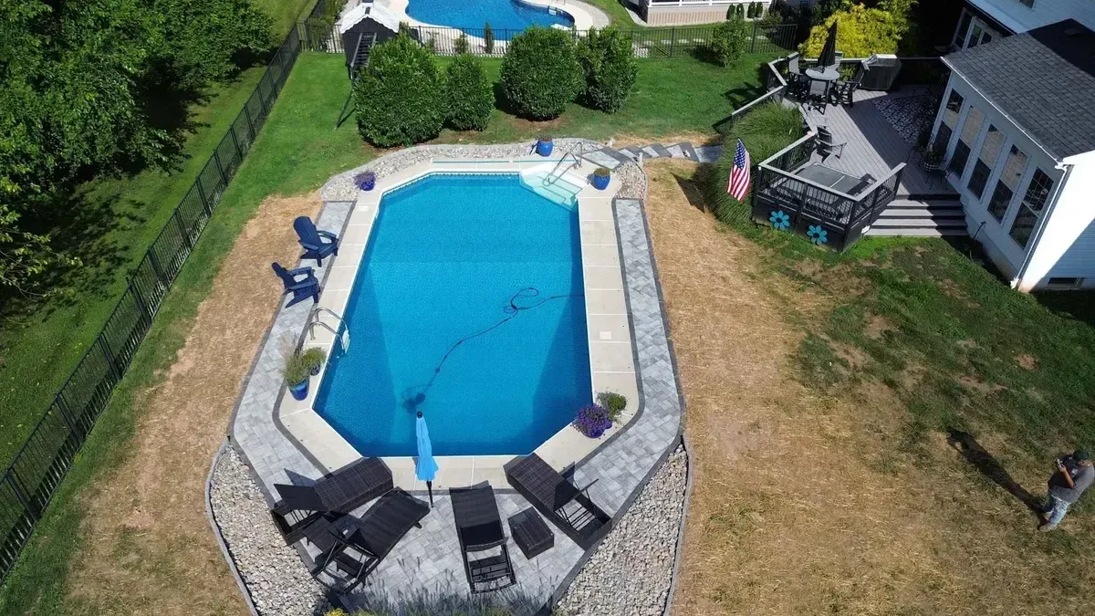 Aerial view of geometric pool with paver coping and stamped concrete patio in Chester County PA