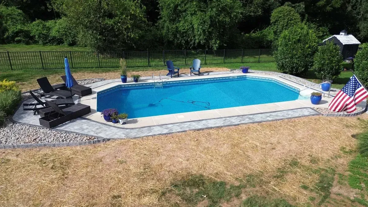 Aerial view of rectangular pool deck with paver coping and river rock in Chester County PA