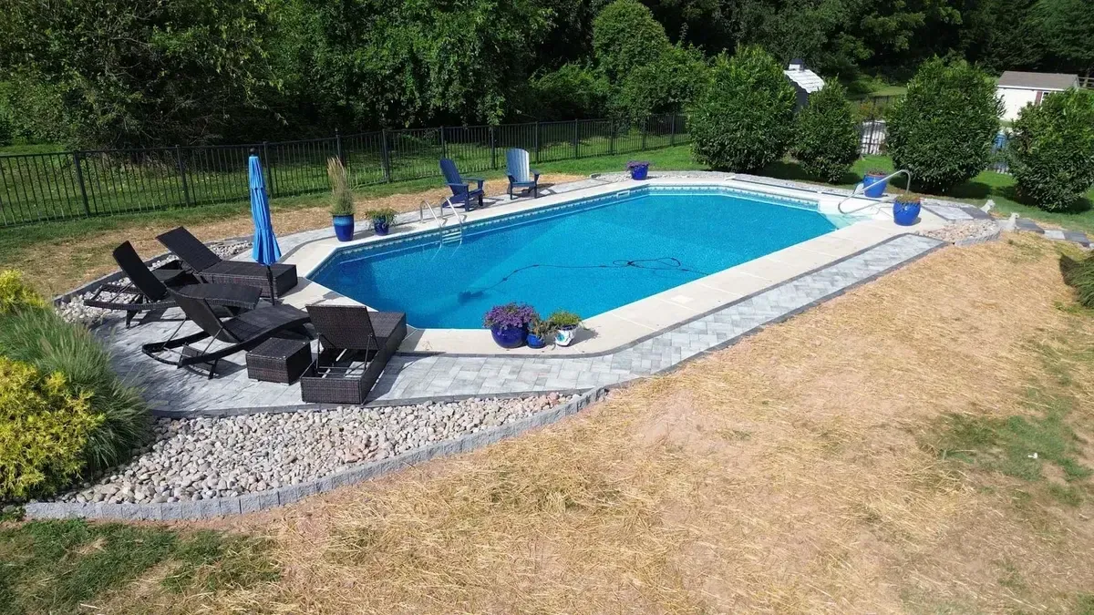 Rectangular pool with paver lounge area and aluminum fencing aerial view in Chester County PA