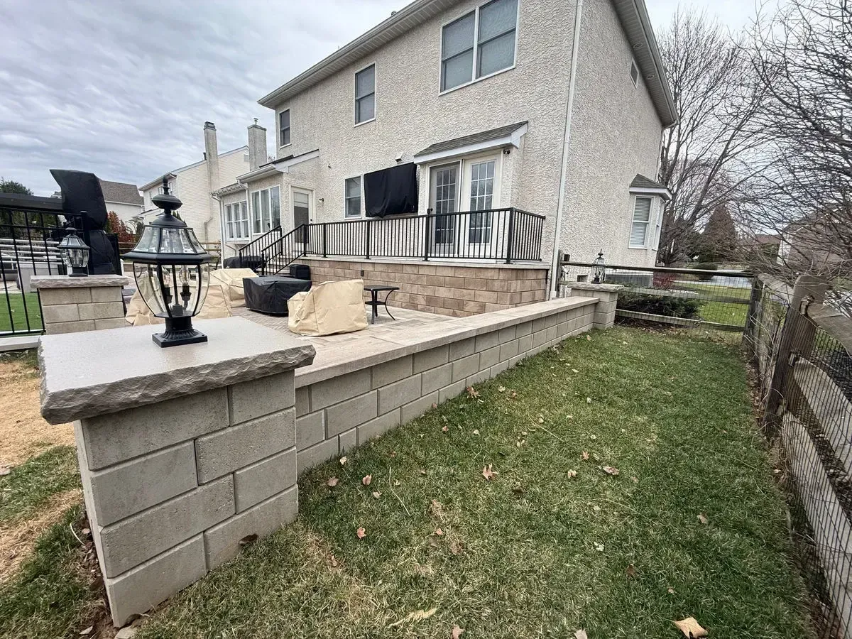 Raised patio retaining wall with pillar lights and railing Chester County PA