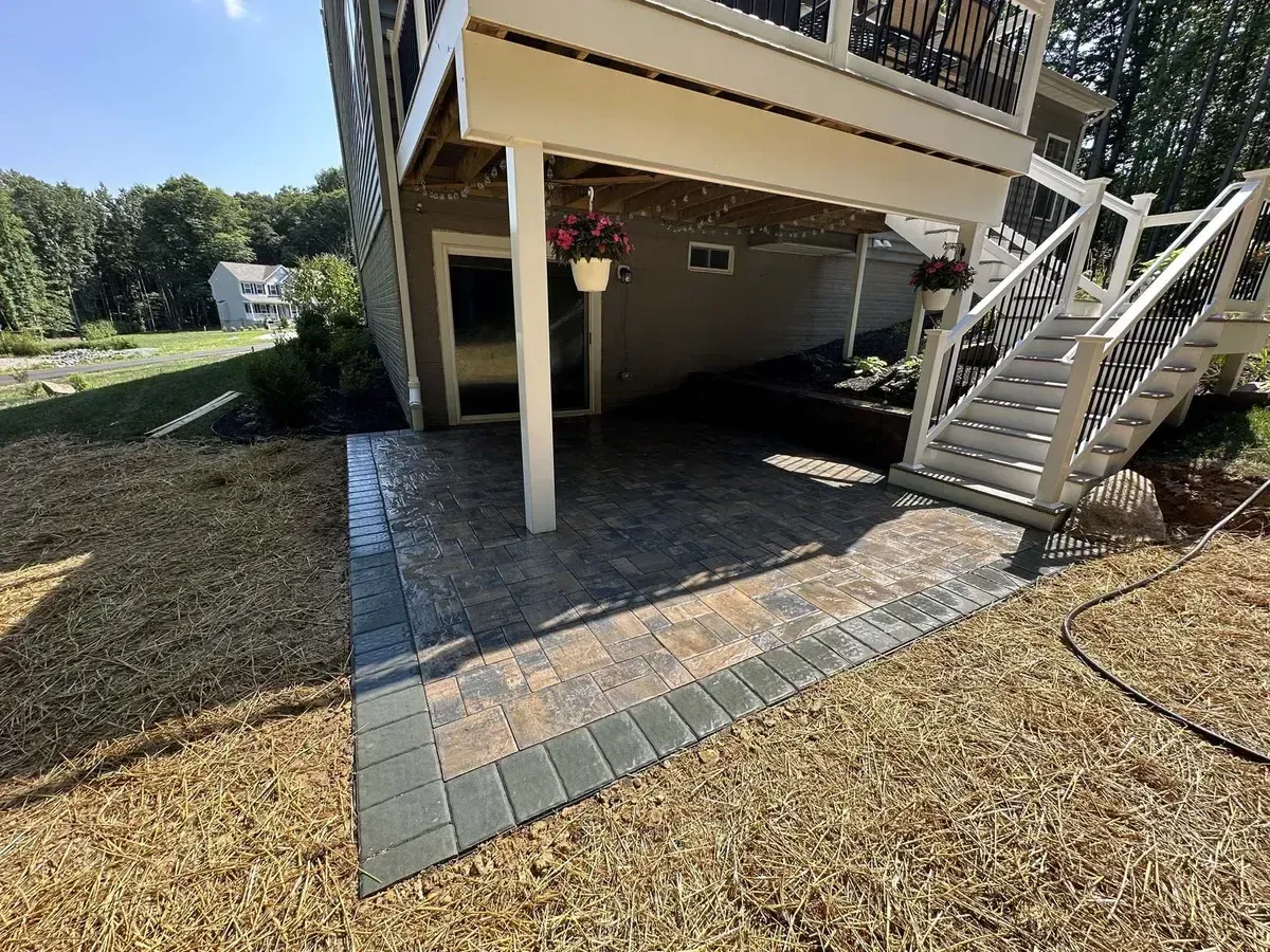 Under-deck paver patio with staircase and hanging planters in Chester County PA