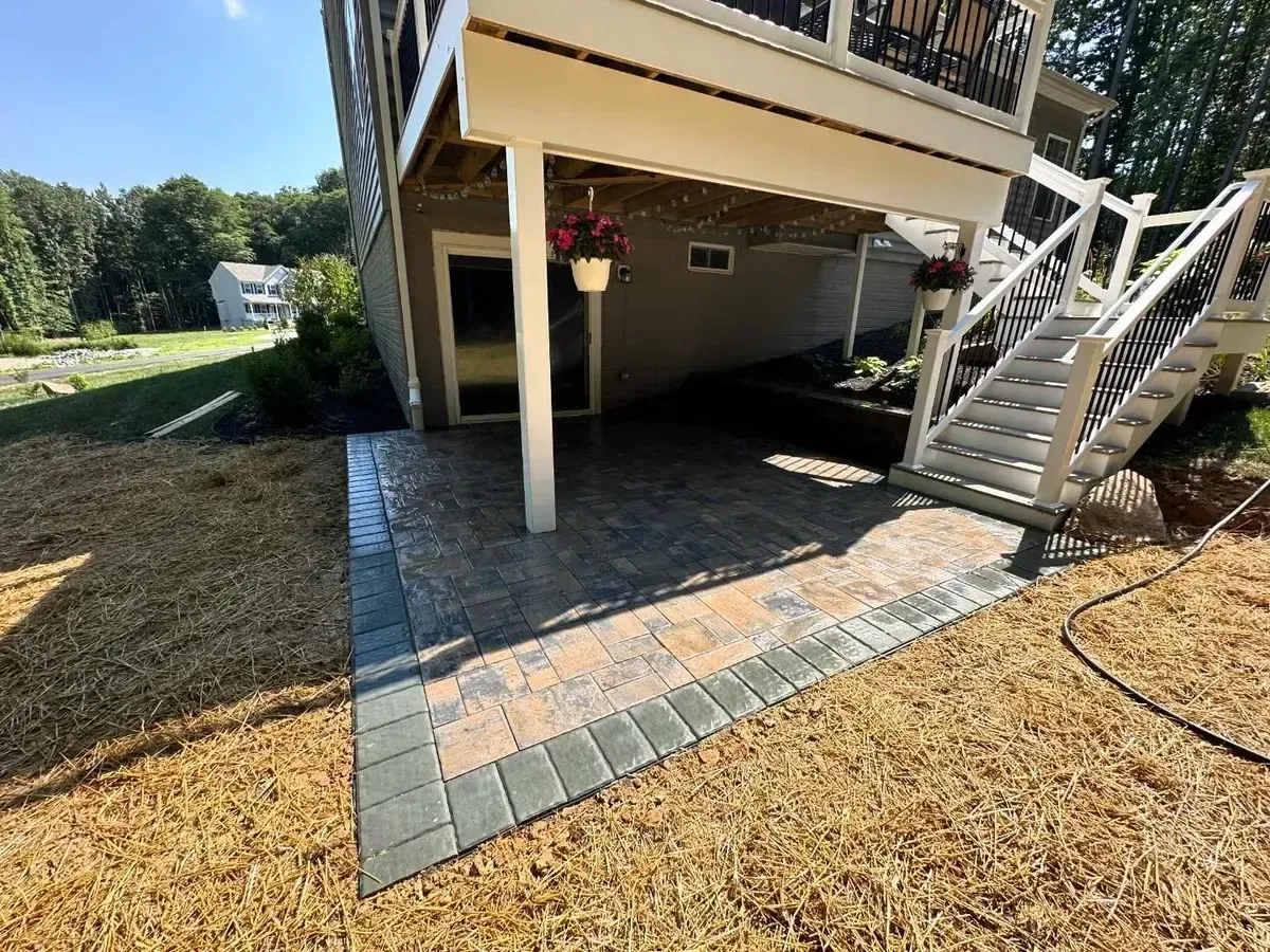 Under-deck paver patio with multi-tone pavers and retaining wall in Chester County PA