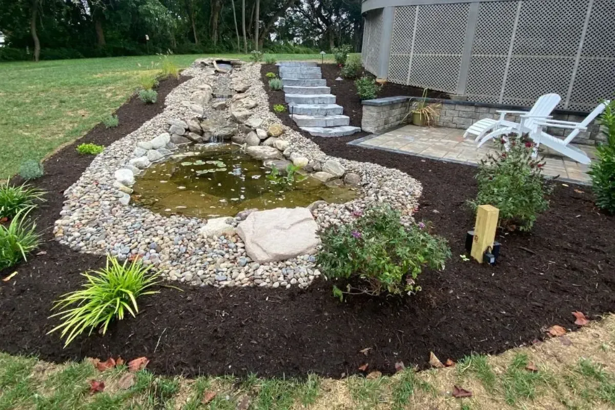 Custom water feature with pond stream and stone patio retreat in Chester County PA